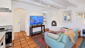 Ein Wohnzimmer mit Fernseher, Sofa und Kamin.