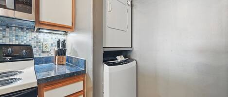 A compact kitchen with a white stove, a microwave, and a built-in dishwasher.