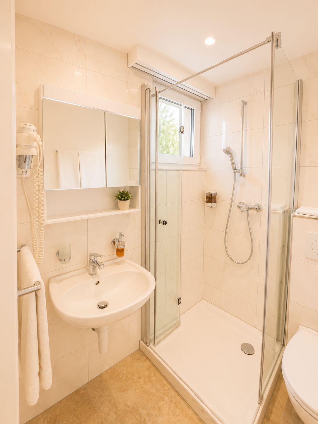 Une salle de bain moderne avec une douche à parois de verre, un lavabo, un miroir et un porte-serviettes.