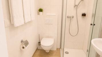 Une salle de bain moderne avec une douche à parois de verre, des toilettes et un lavabo.