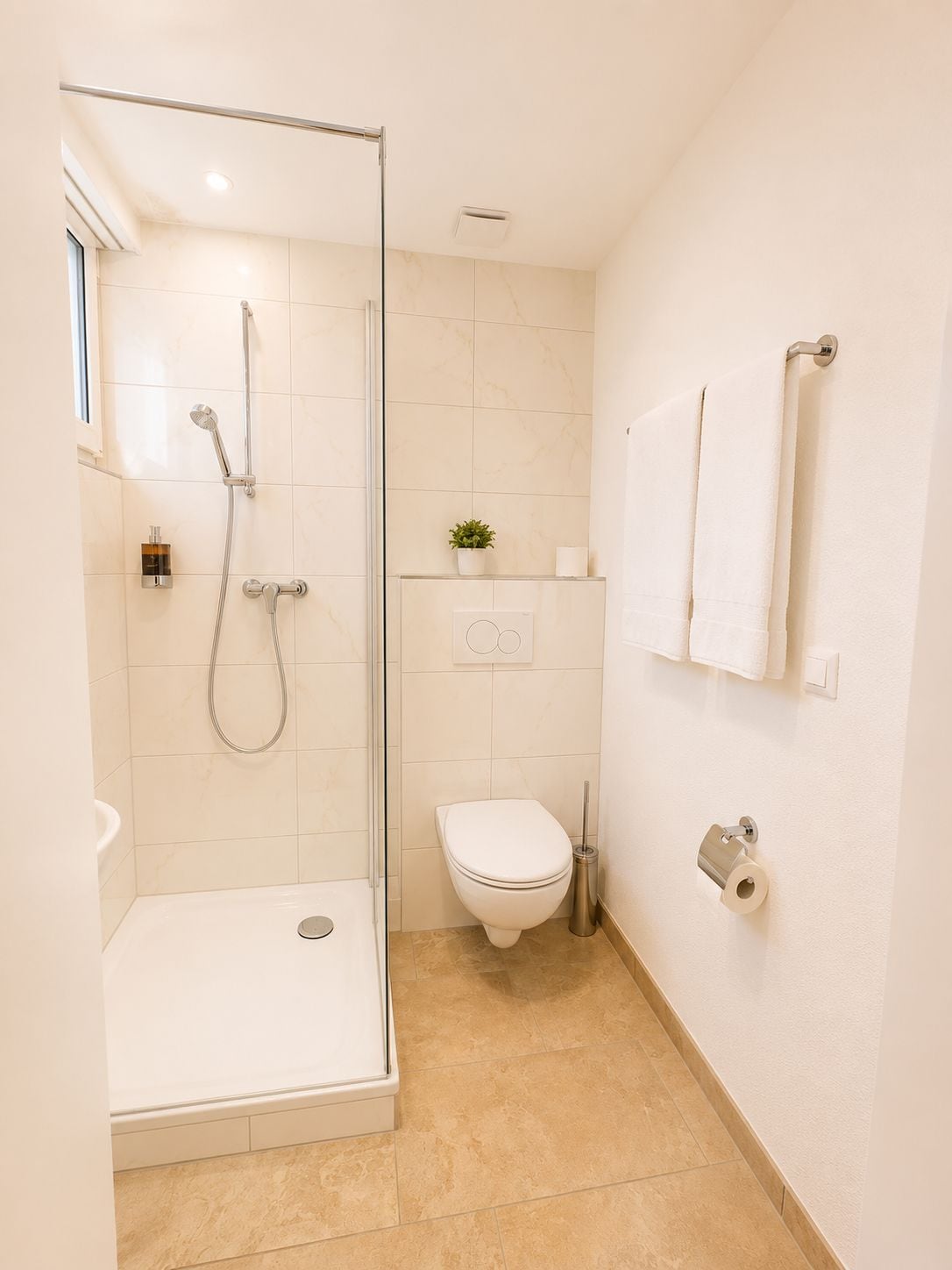 Un baño moderno con ducha envuelta en vidrio, inodoro y lavabo.