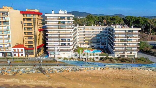 Un hôtel situé sur la côte, doté de nombreux balcons, d’une piscine et offrant une vue sur la plage.