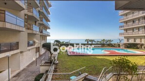 Une vue depuis un balcon donnant sur une piscine et une plage.