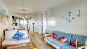 Un salon moderne comprenant un canapé, une table basse et un coin repas avec une table et des chaises.