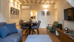 Un espace de vie moderne de style loft, comprenant un coin repas, un canapé, un banc et un escalier.