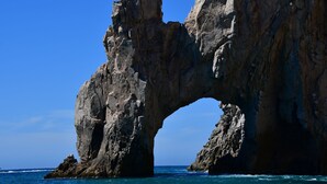 A large natural rock formation with a natural arch over the ocean. - Cabo San Lucas Luxury Executive Suite with Ocean View - sleeps up to 6.  (Cabo San Lucas)
