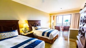 A hotel room with two beds, a balcony, a dining area, and a large wardrobe. - Cabo San Lucas Luxury Executive Suite with Ocean View - sleeps up to 6.  (Cabo San Lucas)
