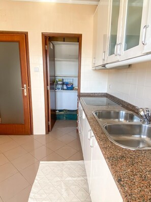 Kitchen features a granite countertop, double sink, and white cabinets.