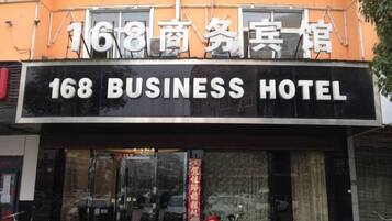 The exterior of a hotel with a sign reading '168 BUSINESS HOTEL'.