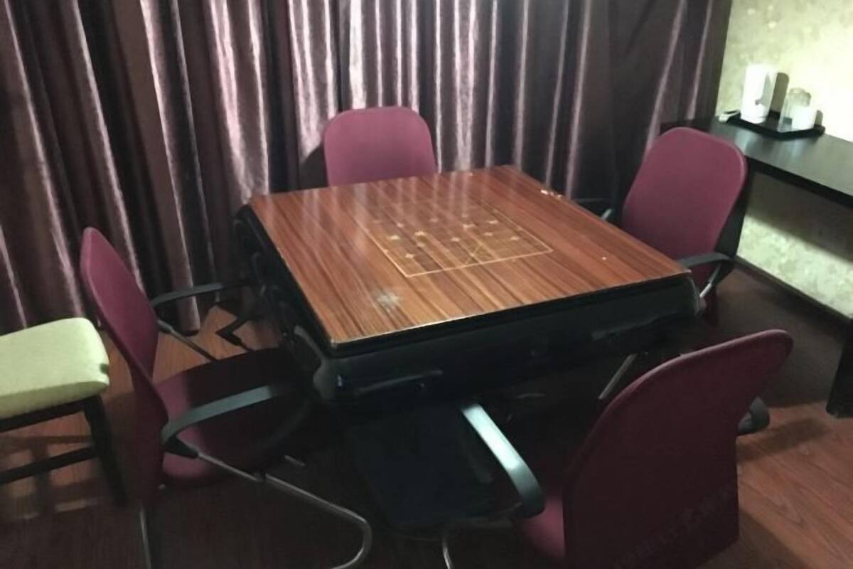 Ein Konferenzraum mit einem Holztisch und vier roten Stühlen.