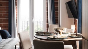 A dining area with a brick wall, a sofa, and a TV mounted on the wall. - 3 bd in zona 2 (Ciudad de Guatemala)