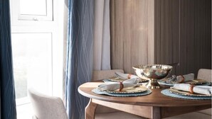 A round dining table with a wooden finish, set with plates, cutlery, and a decorative bowl. - 3 bd in zona 2 (Ciudad de Guatemala)