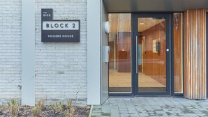 Een moderne gebouw ingang met een bord waarop staat: The Dice Block 2 Vickers House.