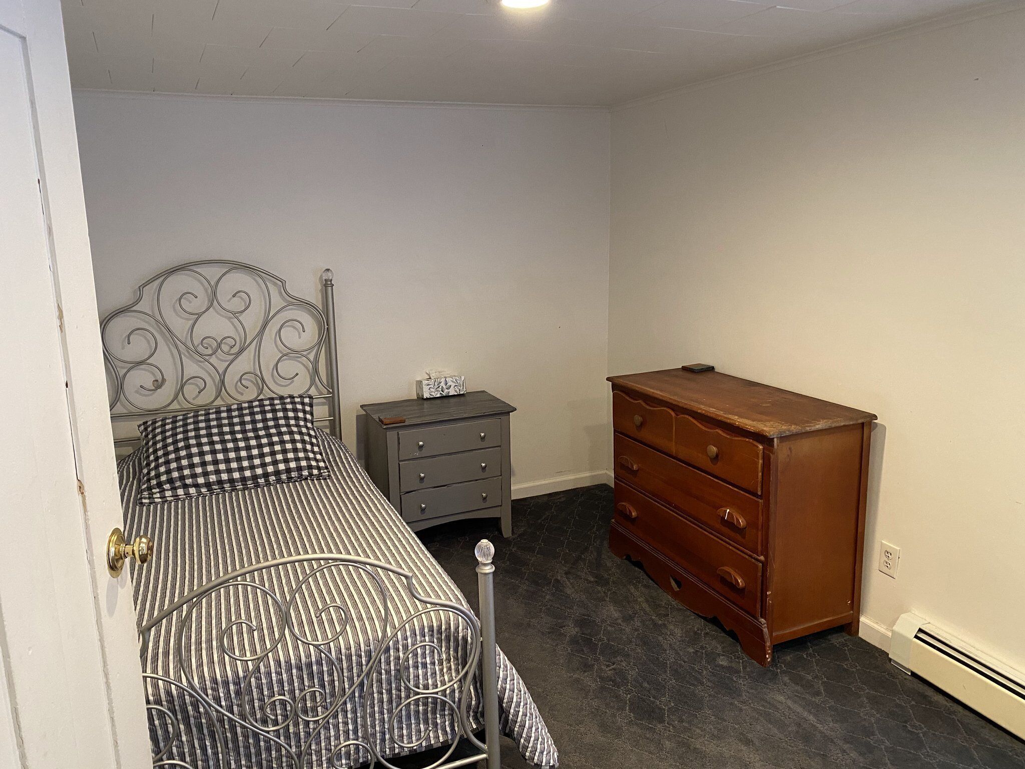 A bedroom with a bed, a dresser, and a nightstand.