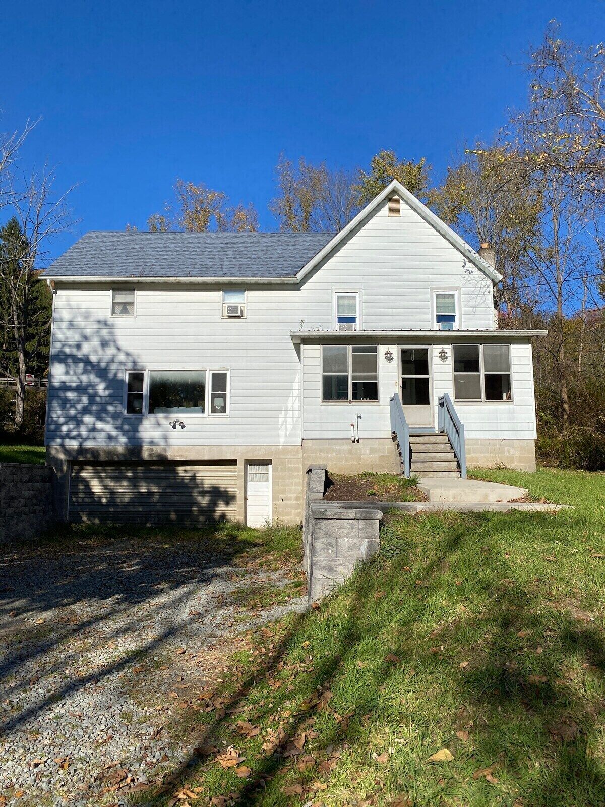 A two-story house with a garage, a front porch, and a small front yard.