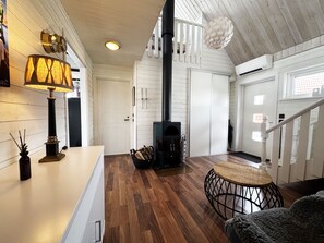 A modern interior with a wood-burning stove, a staircase, and a dining area. - Holiday home in beautiful Kungshamn – perfect for two families | SE09079 (Kungshamn)