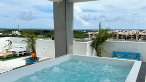 A rooftop hot tub with a view of the cityscape.
