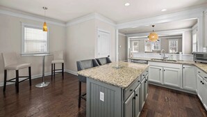 A modern kitchen with granite countertops, white cabinetry, and a central island. - Charming Uptown Charlotte Oasis with En Suites & Balcony with quiet street, walk to coffee shops nearby and minutes to convention center and uptown offices. (Charlotte)