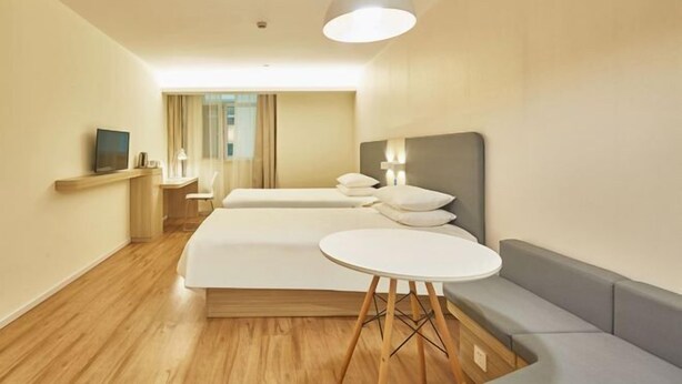 A modern hotel room with a large bed, a small desk, a round table, and a sofa. - Tianyue Hotel (Shangqiu Ancient City First People's Hospital) (Shangqiu)