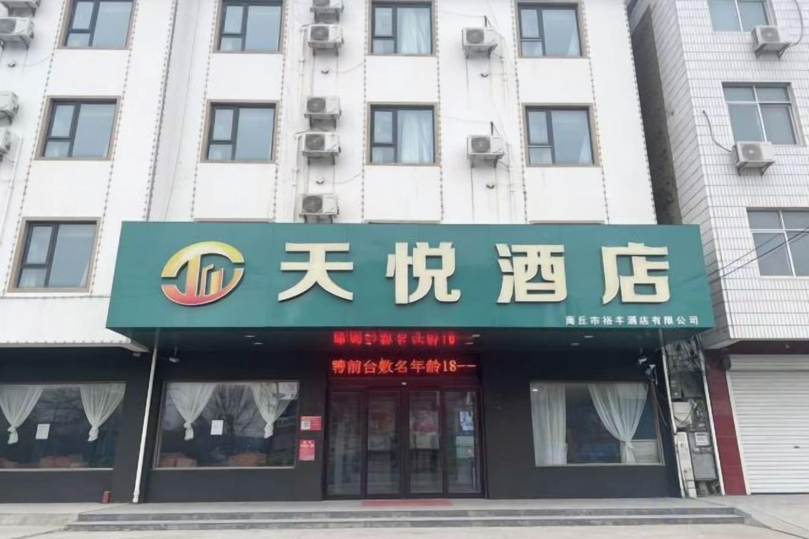 A hotel with a green signboard displaying the name '天悦酒店'.