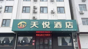 A hotel with a green signboard displaying the name '天悦酒店'.