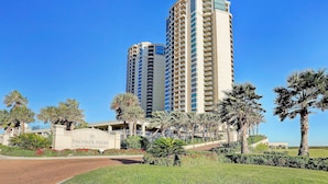 Hotelli, jonka kyltissä lukee ”Palisade Palms 801 East Beach Drive”, ja jonka ympärillä on palmuja sekä hyvin hoidettu nurmikko.