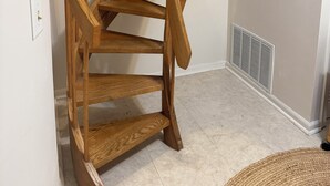 Un escalier en colimaçon en bois, doté d’une rampe et d’un palier.