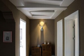 Un pasillo con un adorno de cabeza de ciervo montado en la pared, armarios de madera y puertas.