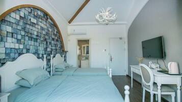 A bedroom with a large bed, a desk, a television, and a unique mosaic wall.