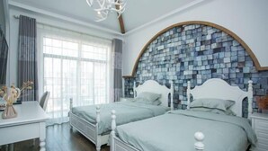 A bedroom with two beds, a desk, and a large window. - Fallen Bay (Shengsi)