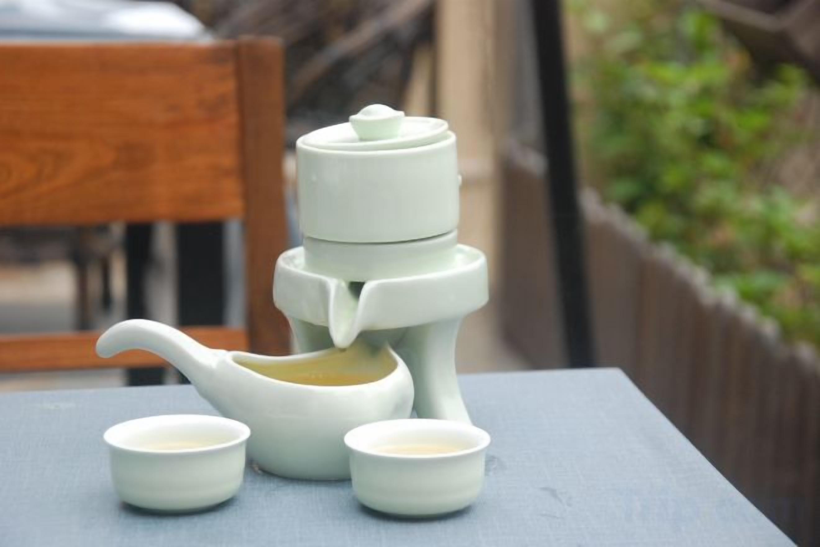 A tea set with a teapot and two cups on a table.