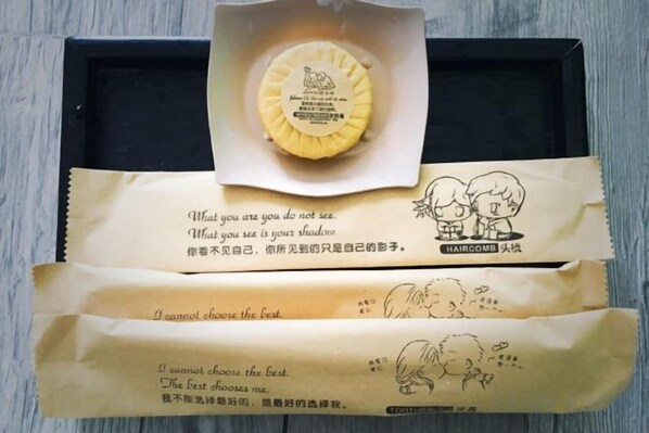 A black tray with a round object on top and two brown papers with text and illustrations.