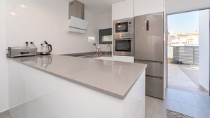 A modern kitchen with a large island, built-in appliances, and a view to the outside. - Casa Blanca (Pilar de la Horadada) (Pilar de la Horadada)
