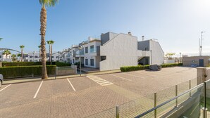 A modern building with a flat roof, a parking area, and a clear sky. - Casa Blanca (Pilar de la Horadada) (Pilar de la Horadada)