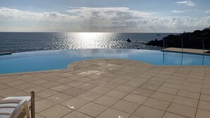 Una piscina con vista al océano y un cielo despejado.