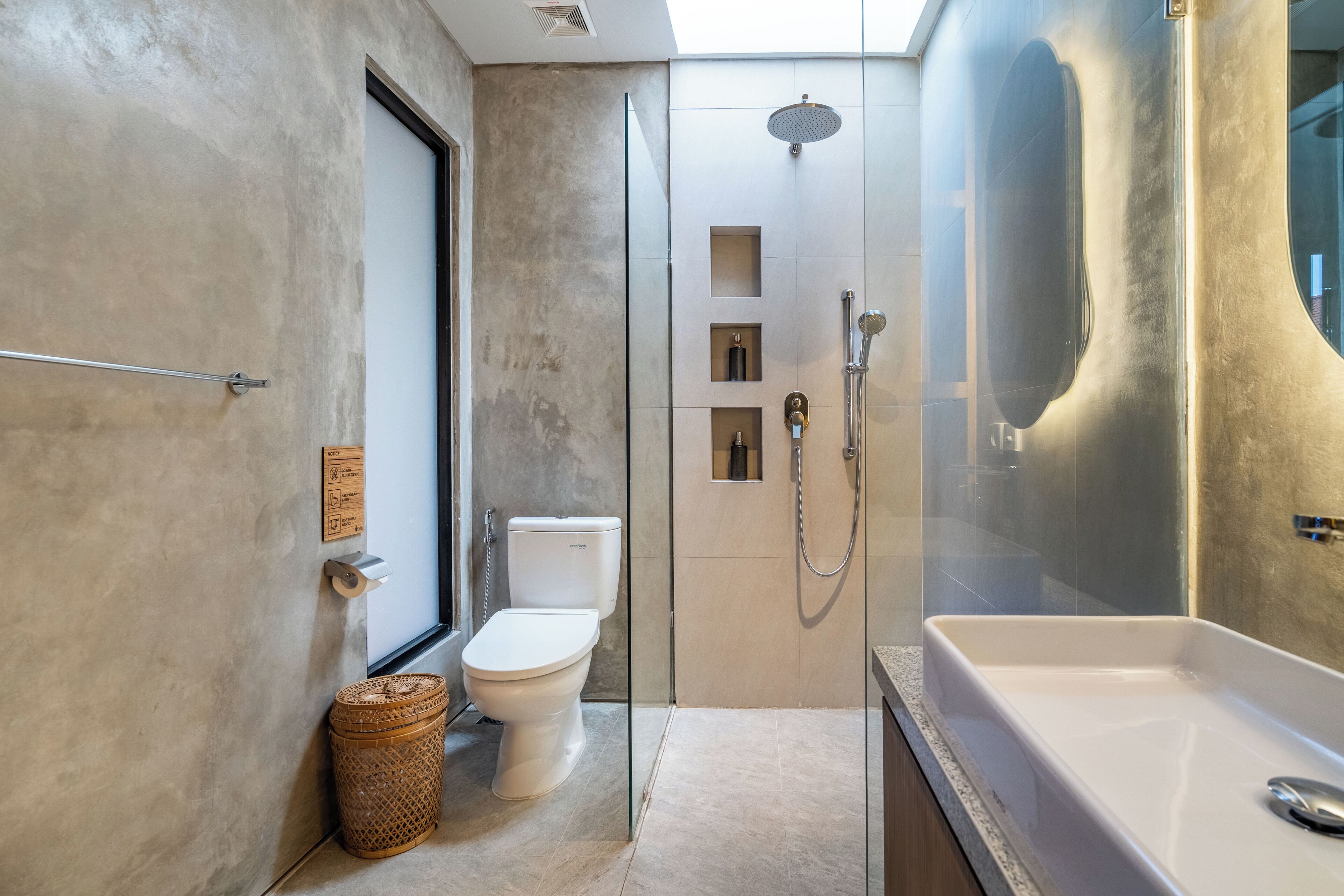 Een moderne badkamer met een douchecabine van glas, een wit toilet en een bad.