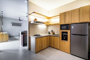A modern kitchen with wooden cabinets, stainless steel appliances, and a built-in microwave.