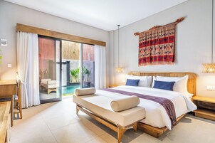 A modern bedroom with a large bed, a bench, a view of a pool, and a sliding glass door.
