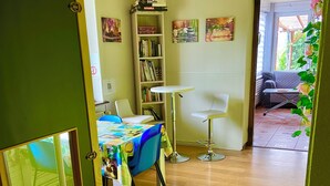 Een kamer met een houten vloer, een bureau met stoel, een boekenkast en een raam.