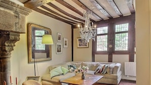 A cozy living room with a sofa, chairs, a coffee table, and a chandelier.