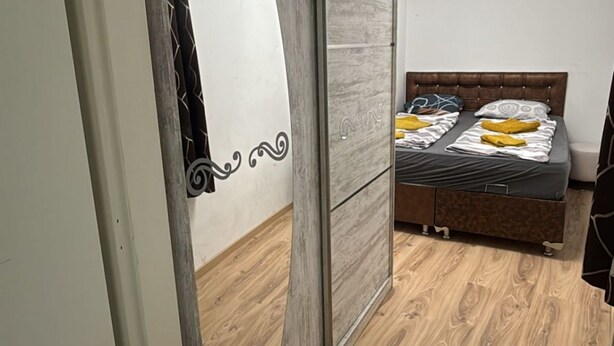 Ein Schlafzimmer mit Bett, Holzboden und Kleiderschrank.