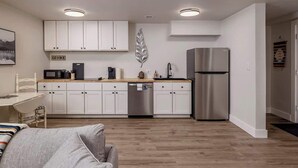 Een moderne keuken met witte kasten, roestvrijstalen apparatuur en een houten aanrecht.