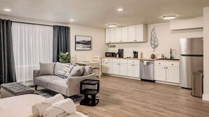 Een modern appartement met een woonkamer, een kitchenette en een eethoek.