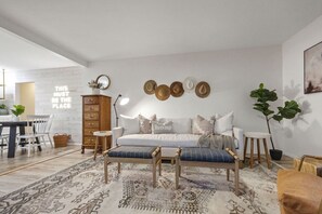 A modern living room with a sofa, a coffee table, a wooden cabinet, and a dining area with a table and chairs. - Aztec St Hilside Retreat- 0.5mi to Downtown! (Prescott)
