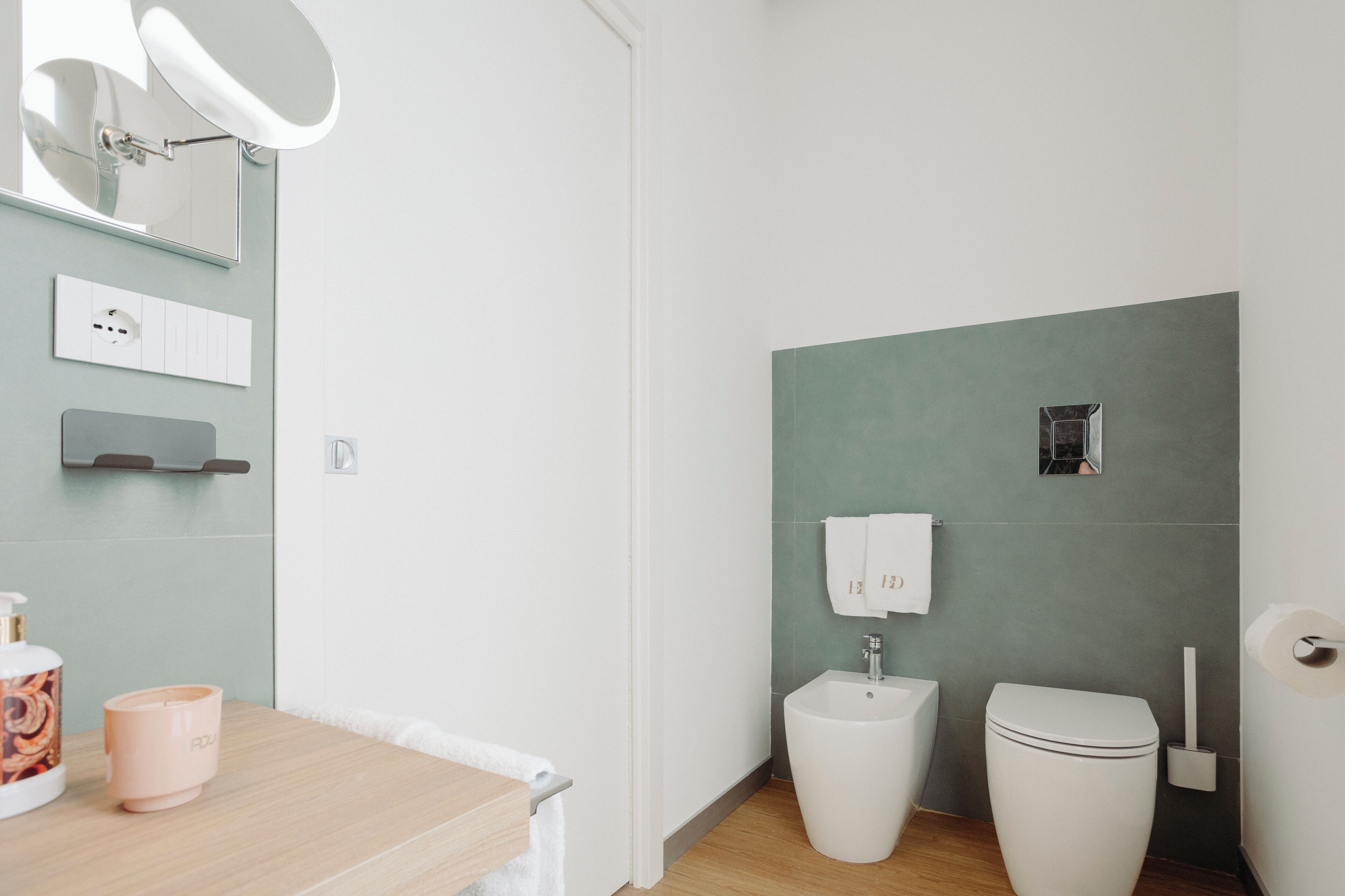 A modern bathroom with a toilet, bidet, and sink.