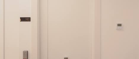 Puerta cerrada de un ascensor con un panel de control y una pantalla digital en la pared.