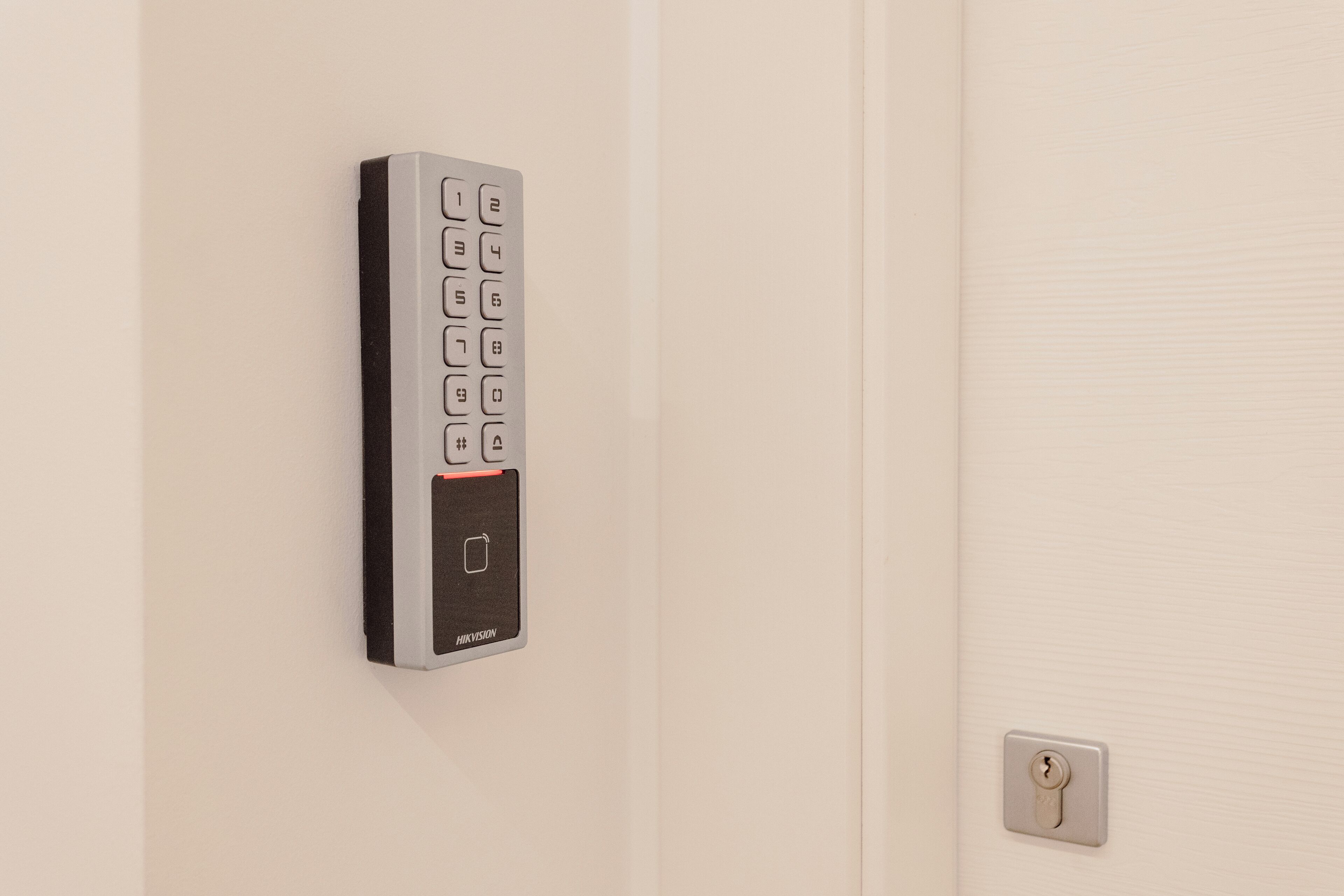 A wall-mounted electronic keypad lock on a door.
