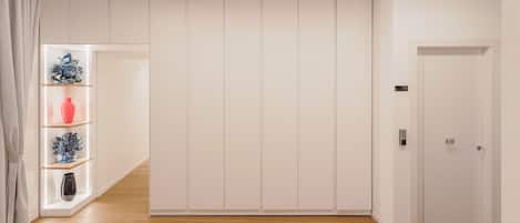 A modern room with a wooden floor, white walls, and a built-in wardrobe with a door marked '10'.