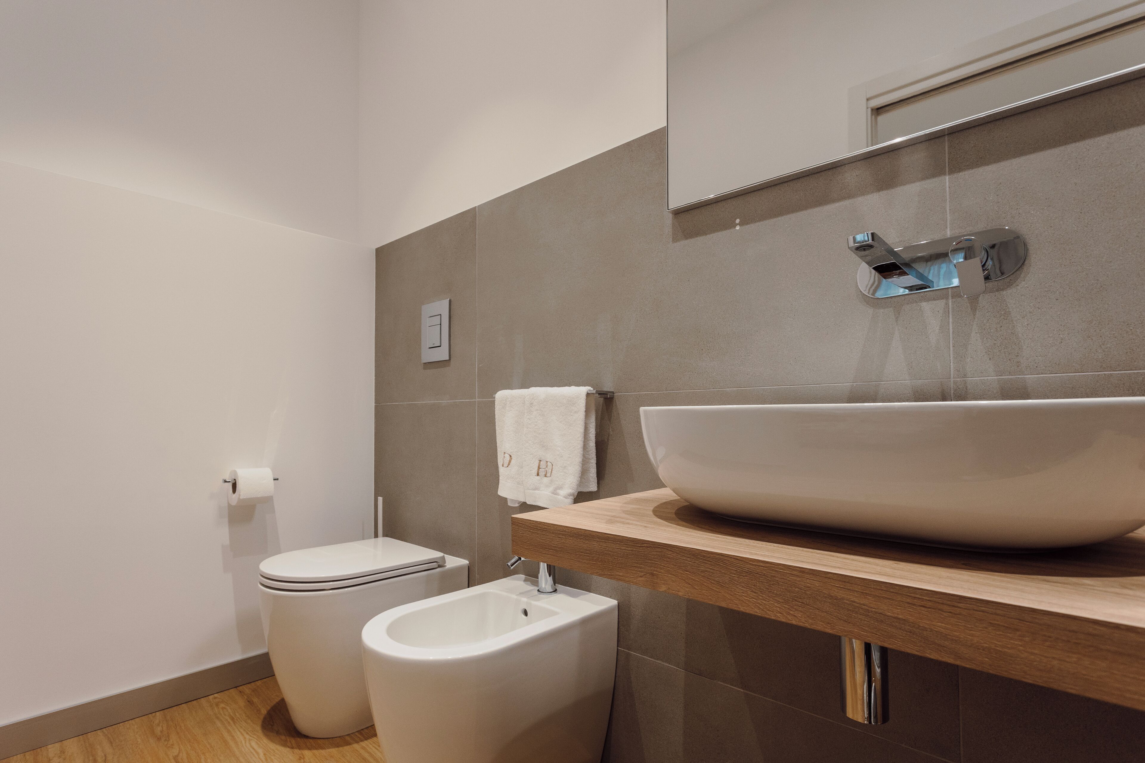Un baño moderno con un lavamanos grande tipo recipiente, un bidé y un inodoro.
