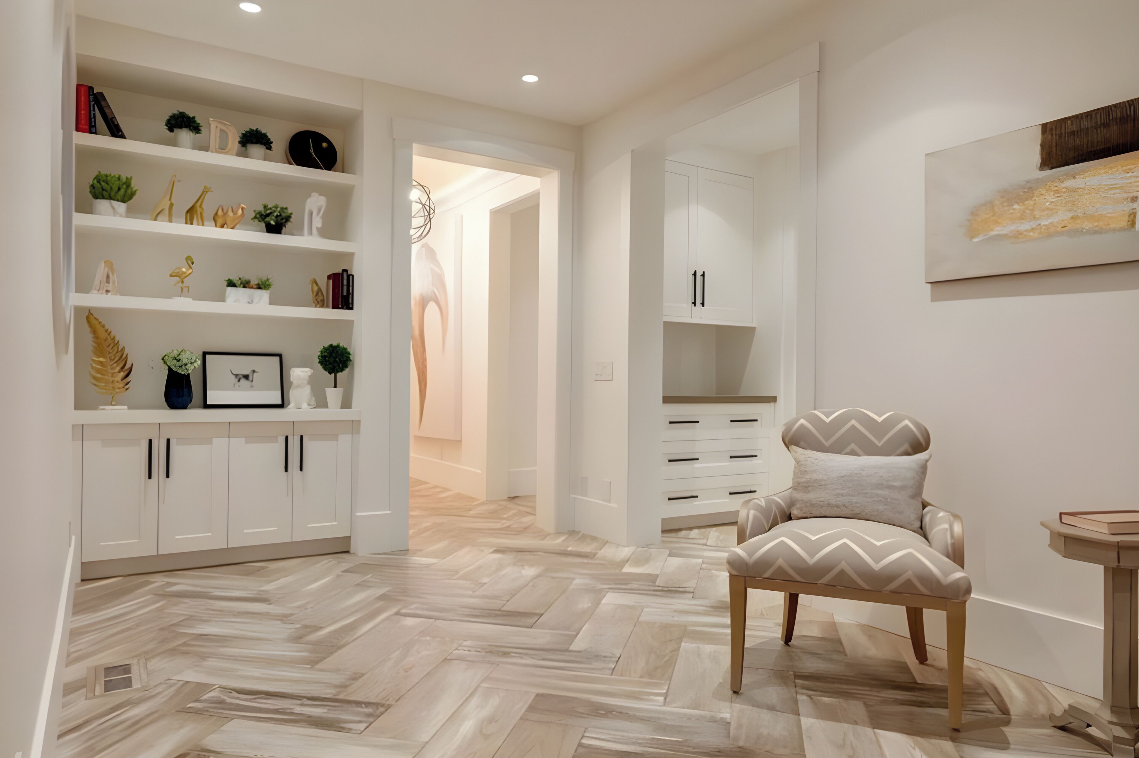 Un intérieur moderne avec un parquet en chevrons, des meubles blancs et un fauteuil décoratif.